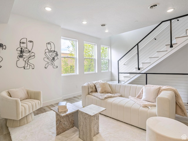 living area featuring recessed lighting, stairway, light wood finished floors, and baseboards