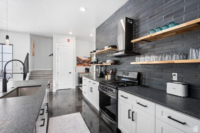 kitchen featuring stainless steel range with gas cooktop, decorative backsplash, wall chimney range hood, pendant lighting, and white cabinets