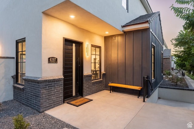 exterior entry at dusk featuring a patio
