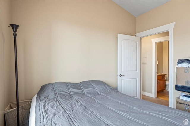 bedroom featuring light carpet and ensuite bath