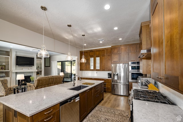 1283 N Gallen Rd W, Santa Clara, UT 84765 - kitchen with light stone countertops, appliances with stainless steel finishes, decorative light fixtures, sink, and a kitchen island with sink