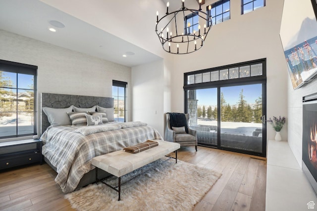 7242 Lupine Dr, Park City, UT 84098 - bedroom featuring access to exterior, wood-type flooring, multiple windows, a chandelier, and a towering ceiling