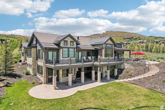 7242 Lupine Dr, Park City, UT 84098 - rear view of house featuring stone siding, a standing seam roof, a patio area, a lawn, and metal roof