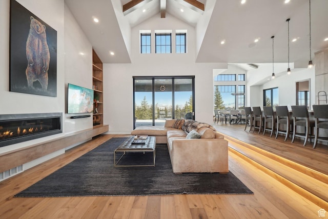 7242 Lupine Dr, Park City, UT 84098 - living room featuring hardwood / wood-style floors, healthy amount of natural light, beamed ceiling, high vaulted ceiling, and a glass covered fireplace