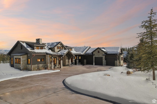 7242 Lupine Dr, Park City, UT 84098 - view of front facade featuring stone siding, a chimney, and an attached garage