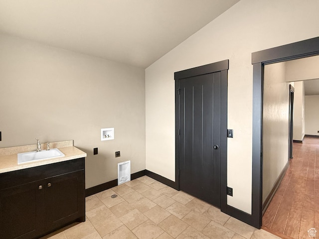 clothes washing area with baseboards, washer hookup, a sink, cabinet space, and electric dryer hookup