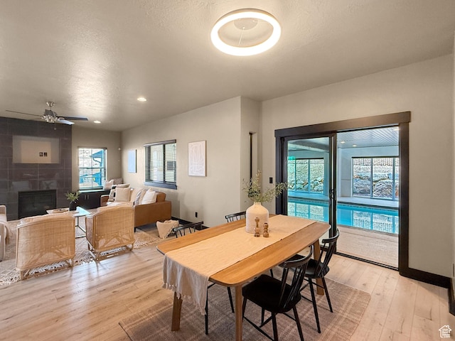 dining area with a fireplace, ceiling fan, light wood-style flooring, and recessed lighting