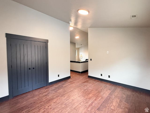 empty room featuring baseboards, visible vents, and wood finished floors