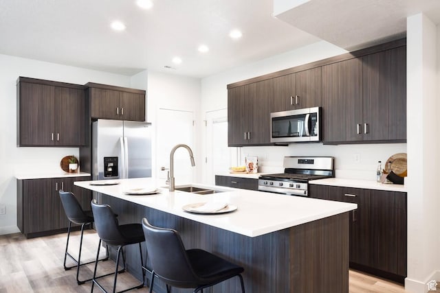 328 E 3390 S Unit 11, South Salt Lake, UT 84115 - kitchen with an island with sink, stainless steel appliances, a kitchen breakfast bar, light wood-type flooring, and sink