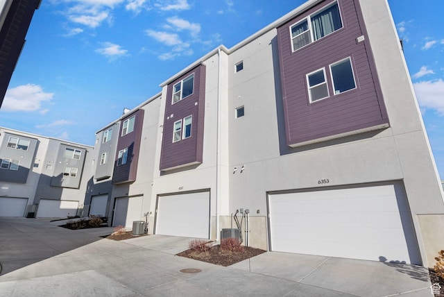 view of property featuring a garage and central AC
