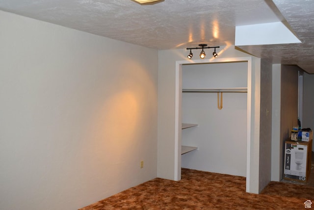 unfurnished bedroom with carpet, a closet, and a textured ceiling