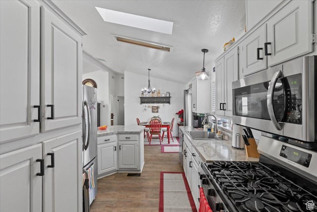 5507 S 1150 W, Riverdale, UT 84405 - kitchen with stainless steel appliances, a sink, a skylight, a chandelier, and lofted ceiling