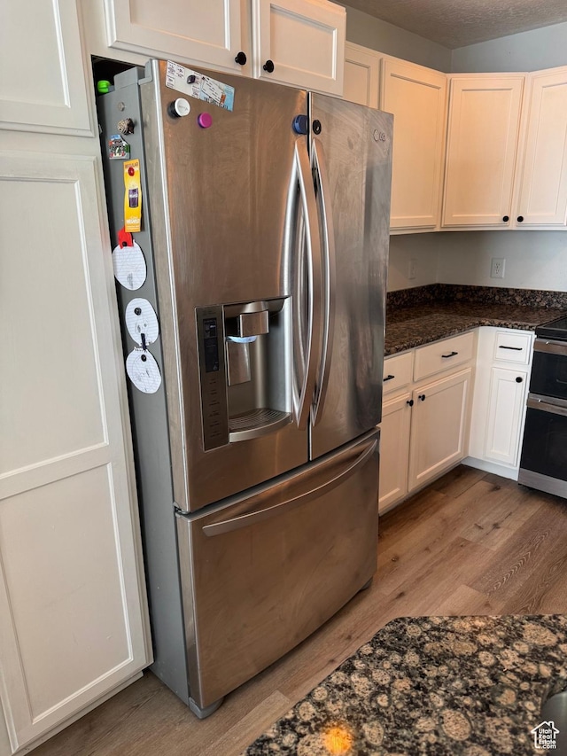 173 E Fidllers Canyon Rd Unit 17, Cedar City, UT 84721 - kitchen with dark stone counters, white cabinets, light wood-style floors, and appliances with stainless steel finishes