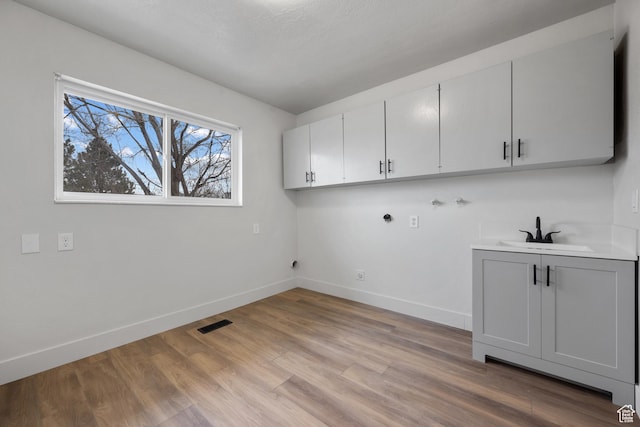 1455 E 100 S, Spanish Fork, UT 84660 - clothes washing area with baseboards, light wood-style flooring, cabinet space, a sink, and washer hookup
