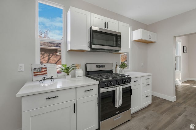 kitchen featuring white cabinetry, stainless steel appliances, and light wood-type flooring