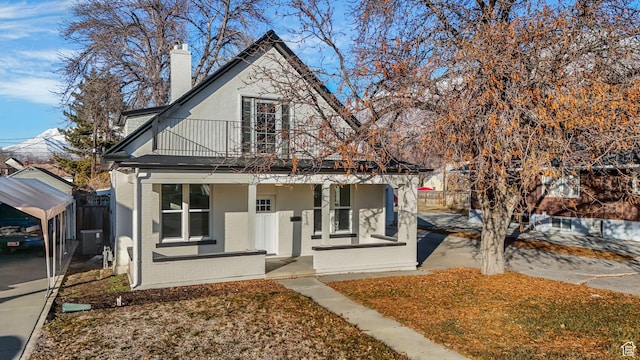 view of front of house with a porch, central AC, and a balcony