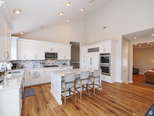 2960 E Oak Park Ln S, Holladay, UT 84117 - kitchen with tasteful backsplash, a sink, a kitchen breakfast bar, stainless steel appliances, and high vaulted ceiling