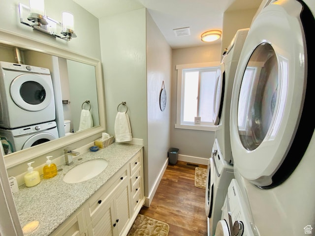37 Wedge Way, Garden City, UT 84028 - bathroom featuring hardwood / wood-style floors, stacked washer / drying machine, vanity, and toilet