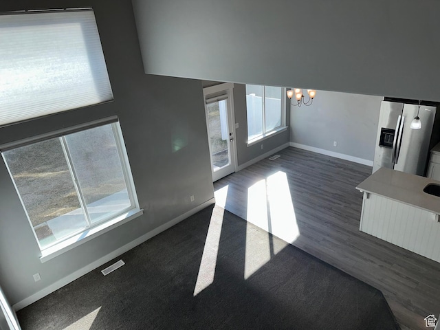 unfurnished living room featuring dark hardwood / wood-style floors and a chandelier