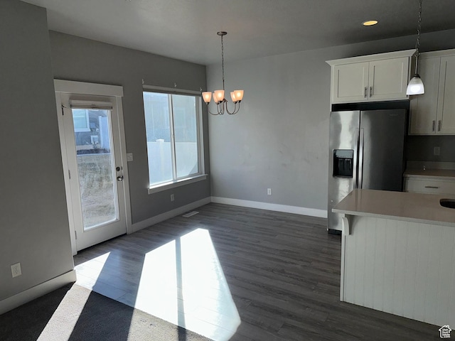 kitchen with stainless steel fridge with ice dispenser, white cabinetry, pendant lighting, and a chandelier