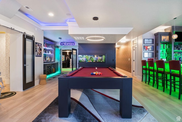 recreation room with crown molding, a barn door, hardwood / wood-style floors, and billiards
