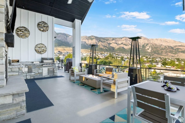 view of patio featuring an outdoor living space with a fire pit, a mountain view, and area for grilling