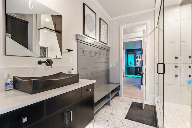 bathroom with tile patterned flooring, crown molding, a shower with shower door, and vanity