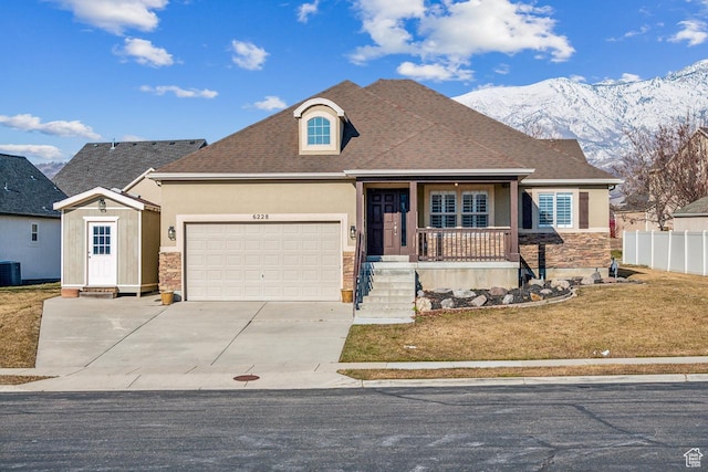 6228 W Apollo Way, Highland, UT 84003 - view of front of property with a front yard, a mountain view, a garage, cooling unit, and covered porch