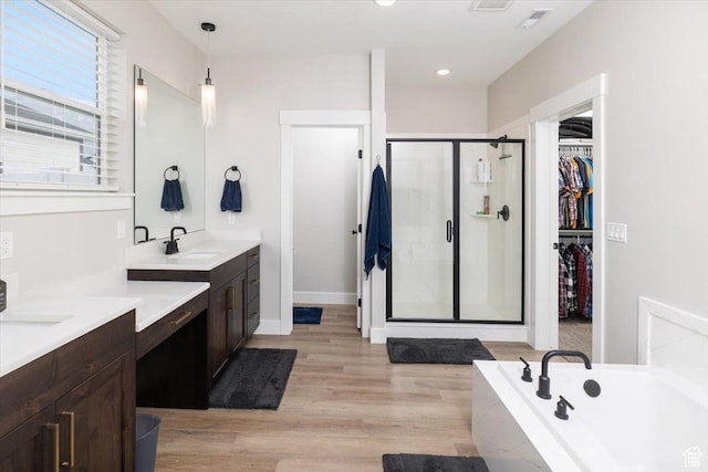 bathroom featuring separate shower and tub, hardwood / wood-style floors, and vanity