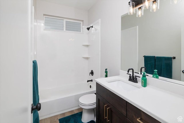 full bathroom with toilet, shower / bathtub combination, hardwood / wood-style flooring, and vanity