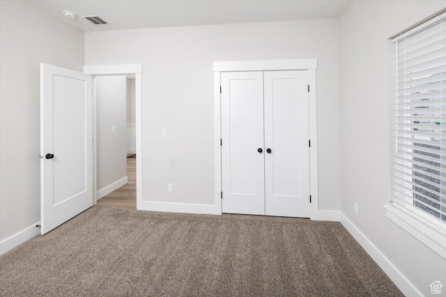unfurnished bedroom with a closet and carpet flooring