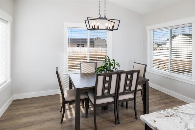 dining space with a healthy amount of sunlight, dark hardwood / wood-style flooring, and a chandelier