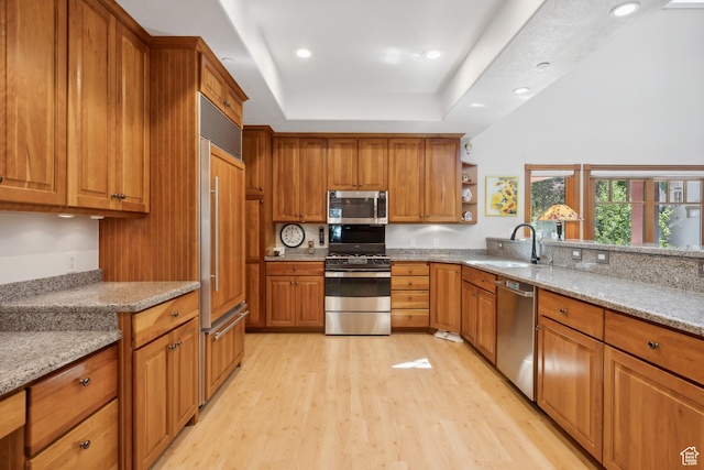 1 Spyglass Ct, Park City, UT 84060 - kitchen featuring stainless steel appliances, sink, light wood-type flooring, light stone counters, and a tray ceiling