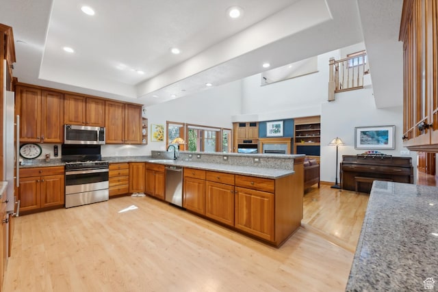1 Spyglass Ct, Park City, UT 84060 - kitchen with light wood-type flooring, kitchen peninsula, light stone counters, and stainless steel appliances