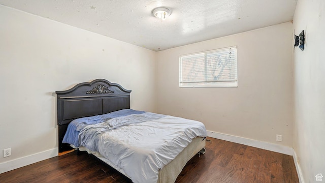 bedroom featuring baseboards and wood finished floors