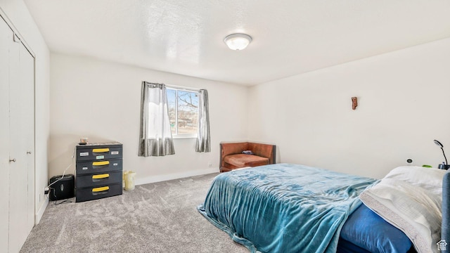 carpeted bedroom with baseboards and a closet