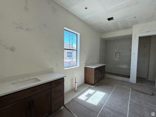 bathroom featuring a textured ceiling and vanity