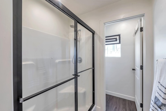 bathroom with a shower with door and hardwood / wood-style flooring