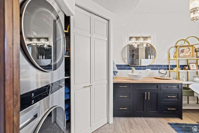 87 N 100 W, Marysvale, UT 84750 - laundry area featuring stacked washing maching and dryer, sink, a textured ceiling, and light hardwood / wood-style flooring