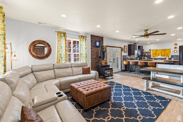 87 N 100 W, Marysvale, UT 84750 - living room featuring ceiling fan, a wood stove, and light hardwood / wood-style flooring
