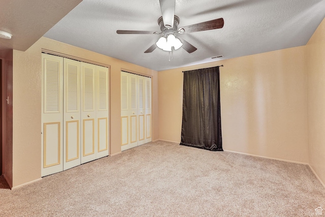 1450 E Gordon Ave N, Layton, UT 84040 - unfurnished bedroom featuring ceiling fan, a textured ceiling, light carpet, and multiple closets