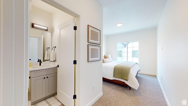 bedroom with sink and light colored carpet