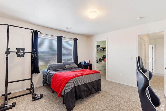 bedroom with visible vents, carpet, baseboards, and a spacious closet