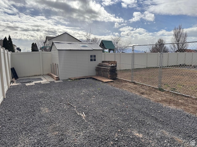 view of yard featuring a fenced backyard, an outbuilding, and a shed