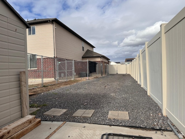 view of yard with a fenced backyard and a gate