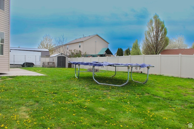 view of yard featuring a patio, a fenced backyard, an outbuilding, and a storage shed