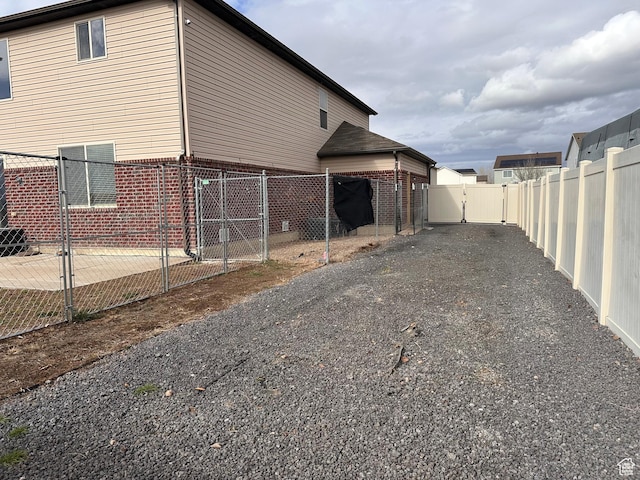 view of home's exterior featuring brick siding, a gate, and a fenced backyard