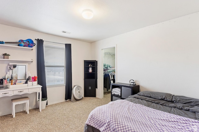 bedroom featuring visible vents, a closet, baseboards, light colored carpet, and a spacious closet