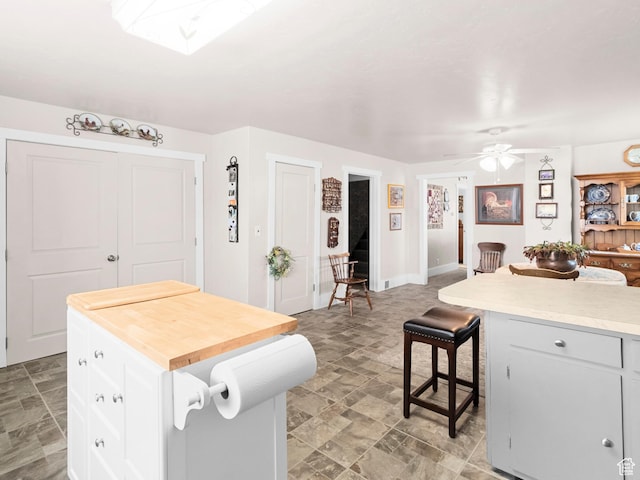 kitchen with white cabinets, a center island, a skylight, and a breakfast bar area