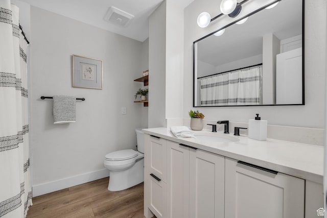 full bath with visible vents, baseboards, toilet, vanity, and wood finished floors